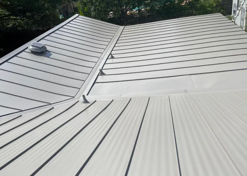 Solar attic fan installed on a metal roof for Roof Ventilation in Hudson